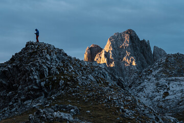 Unrecognizable distant traveler on mountain peak