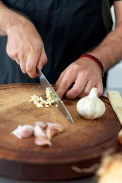 Closeup of a man cutting garlic in the kitchen