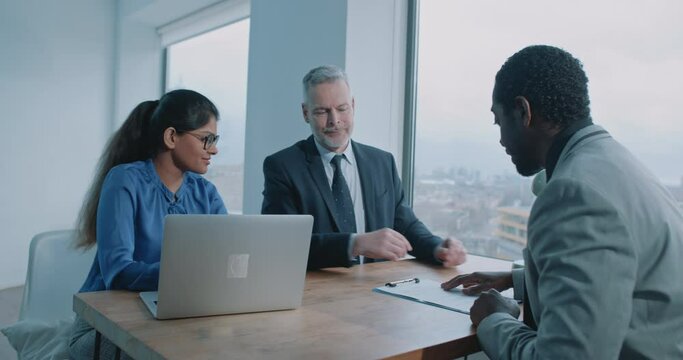 Caucasian businesman handing over a job contract to a African candidate