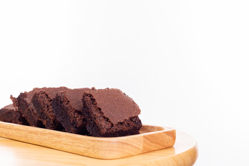 Pieces of fresh brownie on wooden plate with isolated on white background and copy space, selective focus Chocolate brownies  put on wood table Homemade bakery and vegan sweet dessert concept