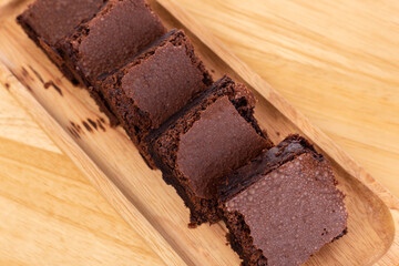Pieces of fresh brownie on wooden plate with top view, selective focus  Chocolate brownies on put on wood table Homemade bakery and vegan sweet dessert concept
