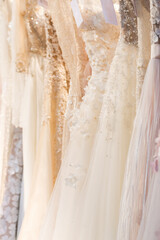 wedding dresses hang on a hanger in a row