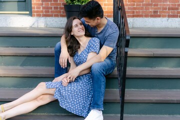 cute couple sitting on steps in town