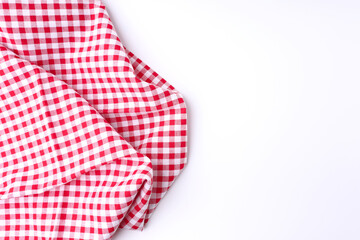 Red and white fabric tablecloth checkered on white background with copy space.