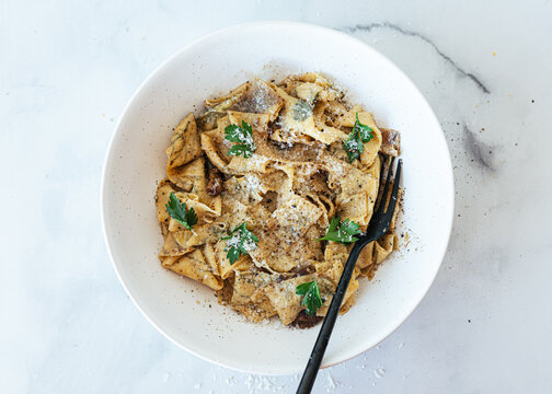 Bowl of pasta with butter browned garlic, shaved parmesan and parsley