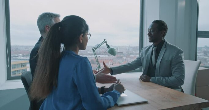 African man signing contract and shaking hands with the recruiters