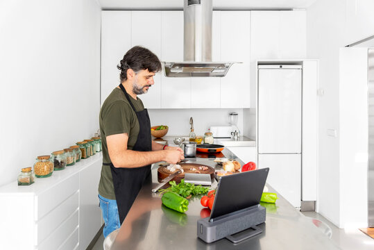 Man cutting red peppers in the kitchen