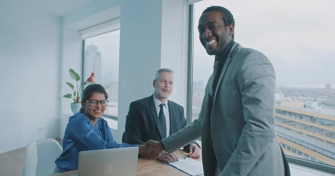 African businessman shake hands with recruiter and smile to the camera 
