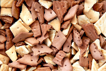 Top view of chocolate graham crackers broken into pieces of crumbs. Background graham crackers