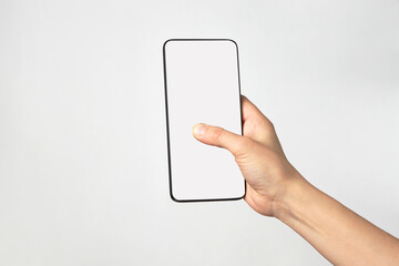 Woman hand holding phone on white background with copy space