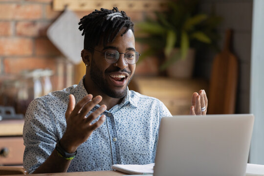 Happy Young Afro American Man Software Developer Run Program Code On Pc Enjoy Reaching Successful Result. Overjoyed Black Guy Look On Laptop Screen Splash Hands Having Winning Hand At Online Blackjack