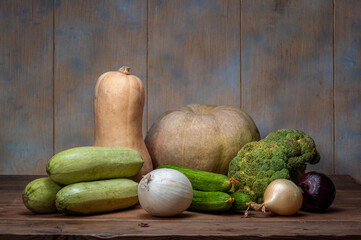 Still life with fresh vegetables. pumpkins, zucchini, cucumbers, onions, on a wooden table High quality photo