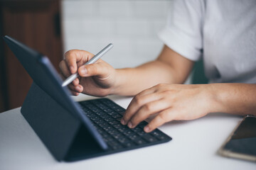 Female hands holding and using digital pen writing on taplet screen , freelance working business at home