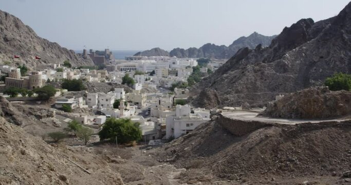 The Al Hajar Mountains and Old Muscat, Oman, wide shot pan left
