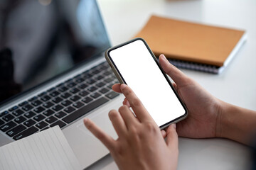 Image. Woman holding a smartphone blank white screen at the office.