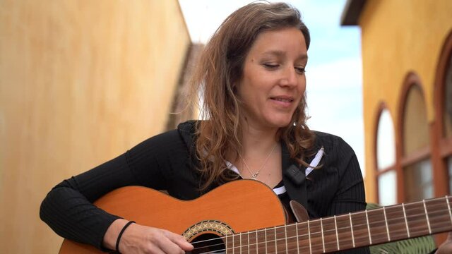 Cantante tocando la guitarra y cantanto en la terrazza