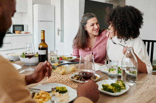 Diverse friends talking over a meal at home