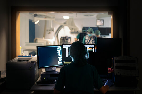 Back View of Faceless Doctor Using Computer
