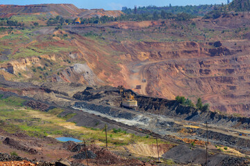 Huge iron ore quarry with working dump trucks and excavators in Kryvyi Rih, Ukraine