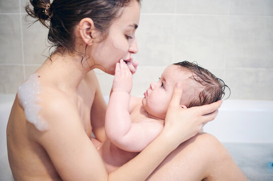 Mother with baby sitting in bathtub