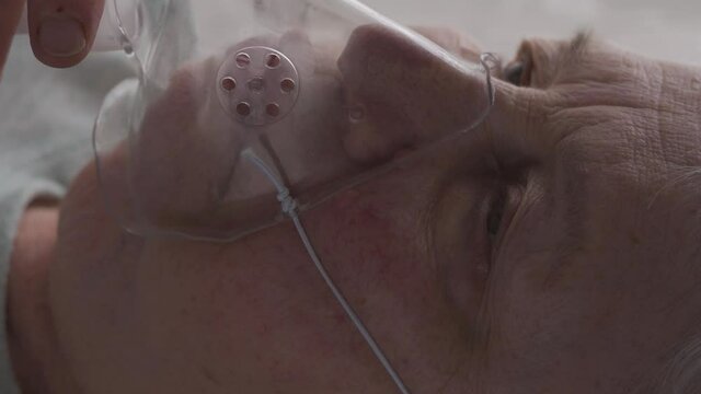 Senior Woman put on and breathing with an oxygen mask. Vertical format
