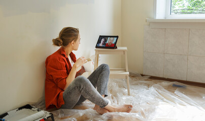 Young woman resting during home renovation and communicating online via tablet