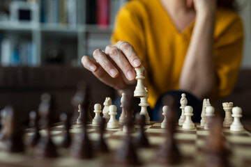 Asian woman playing chess at home