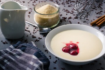 Semolina pudding with cherries and chocolate sprinkles on countertop