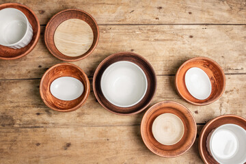 Handmade empty ceramic dishes and plates on wooden background