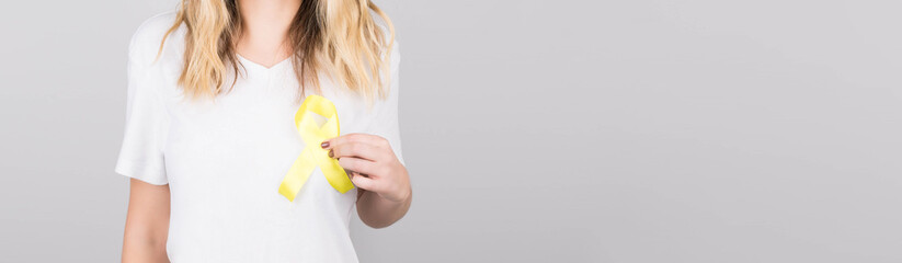Young female in white t-shirt holding yellow ribbon awareness symbol for suicide, sarcoma bone...