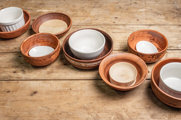 Handmade empty ceramic dishes and plates on wooden background
