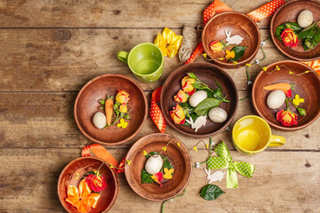 Easter ceramic bowls with eggs, bunnies, and fresh roses on a vintage table