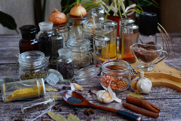 Multi-colored spices in jars on a wooden background.