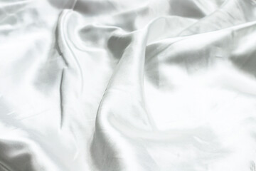 White abstract background texture of soft smooth textile silk fabric. Top view. Flat lay. Close up. Selective focus. Copy space