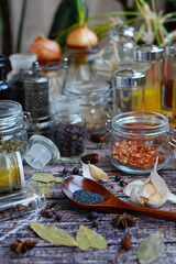 Close-up of glass jars and spoon with spices. Vertical
