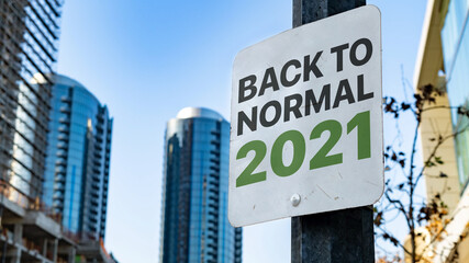 Fototapeta premium Back to Normal 2021 Worn Sign in Downtown city setting