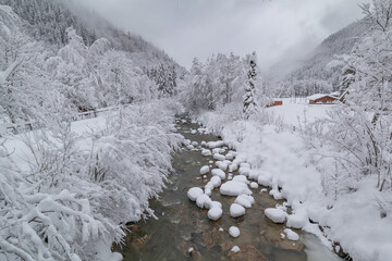 A very snowy river Bon Nant flowing through the pretty French Alpine village of Les Contamines-Montjoie
