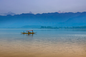 Fototapeta na wymiar Reflection of Himalayan mountains on Dal Lake, Srinagar, Jammu and Kashmir, India. Houseboats floating on the lake in late afternoon.