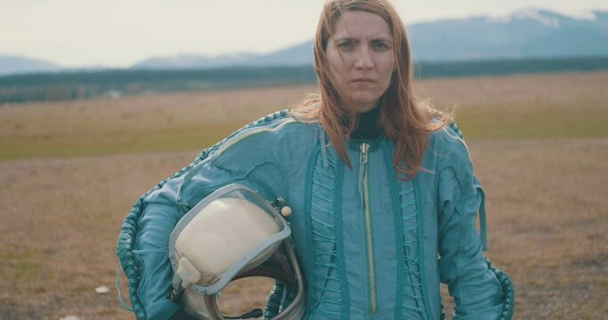 Portrait of a female astronaut holding her helmet on hand.
