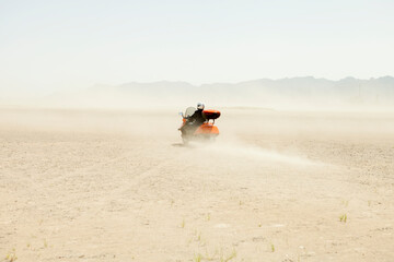 Man Driving a scooter in the desert