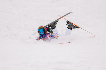 Girl in bright suit beautifully falls on skis