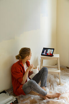 Young woman having video conversation with parents during home repair