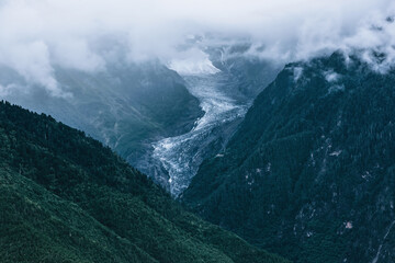 Fototapeta premium A section of glacier under the clouds between high mountains