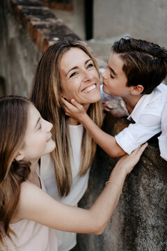 Son and daughter kissing the mother. Family portraits.