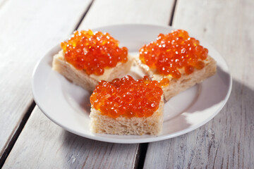 Salmon caviar on pieces of white bread macro