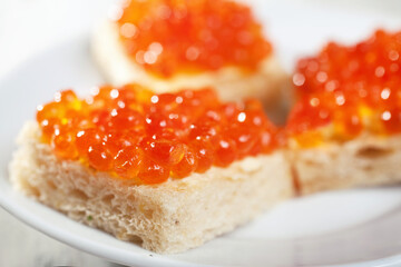 Salmon caviar on pieces of white bread macro