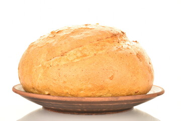 One loaf of delicious white bread on a clay plate, close-up, isolated on white.