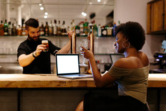 Restaurant manager and waiter toasting at the bar