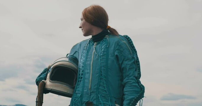 Cosmonaut red hair woman looking around the landing zone.