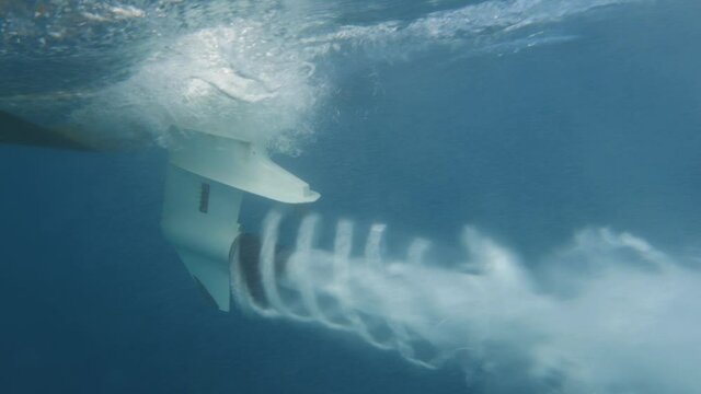 slowmotion lateral close up shot of boat propeller in dea blue dea during sunny day